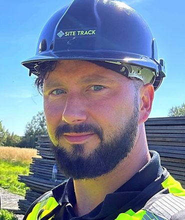 photo of dan brown in a high vis jacket with a black helmet and site track logo